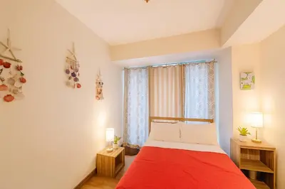 a bedroom with a red bed and a window at Cheapest staycation miami tower azure in Manila