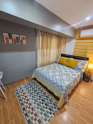 a bedroom with a bed and a rug at Casa Rosa2 2BR loft in BGC with 55 Smart TV 5 pax in Manila
