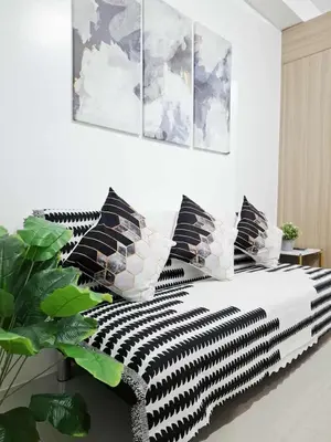 a bedroom with a bed with black and white pillows at Oasis at Shore Residences in Manila