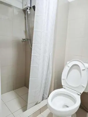 a bathroom with a toilet and a shower at Oasis at Shore Residences in Manila