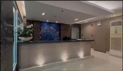 a lobby with a bar with a blue painting on the wall at Sea Residences - Mall of Asia 829B by Forever-mc Condotel in Manila