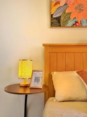 a lamp on a table next to a bed at Mariah Relaxing Minimalist Condo at Filinvest City Alabang in Manila