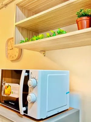 a kitchen shelf with a sewing machine on it at Mariah Relaxing Minimalist Condo at Filinvest City Alabang in Manila