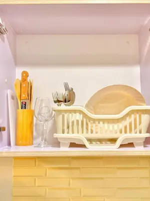 a kitchen shelf with a dish drying rack and a plate at Mariah Relaxing Minimalist Condo at Filinvest City Alabang in Manila