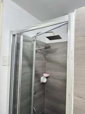 a shower with a glass door in a bathroom at Yakal tanza garden height with Netflix in Tanza