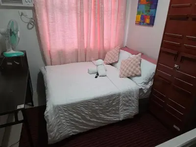 a small bed in a small room with a window at Staycation All In in Manila