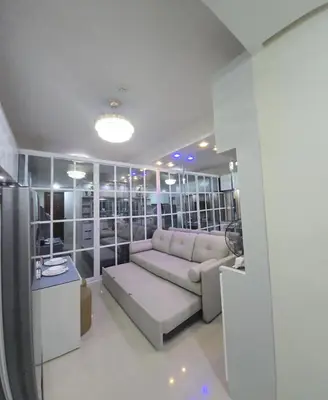 a living room with a couch and a table at 1BR Deluxe Suite pool view with Balcony in Manila