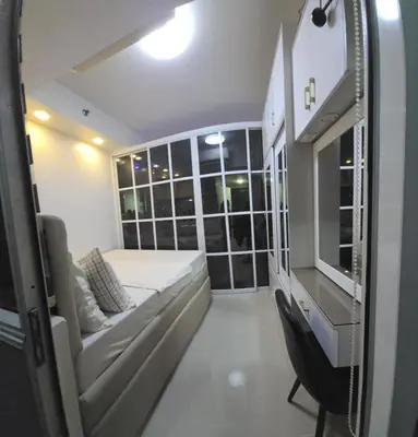 a small room with a bed and a window at 1BR Deluxe Suite pool view with Balcony in Manila