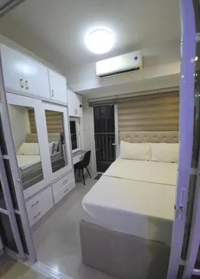 a bedroom with a large bed and a desk at 1BR Deluxe Suite pool view with Balcony in Manila