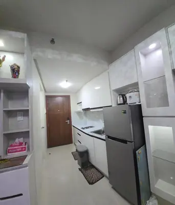a small kitchen with a refrigerator and a sink at 1BR Deluxe Suite pool view with Balcony in Manila