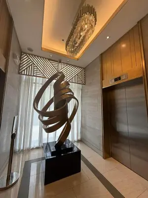 a sculpture of a hand in a lobby at Fame Residences Staycation in Manila