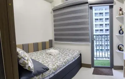 a small bedroom with a bed and a window at Fame Residences Staycation in Manila