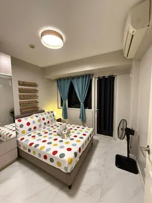 a bedroom with a bed with polka dots on it at 1BR Condo with balcony near MOA,Parqal,Solaire in Manila