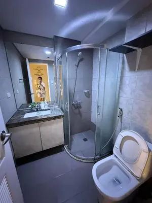 a bathroom with a shower and a toilet and a sink at 1BR Condo with balcony near MOA,Parqal,Solaire in Manila