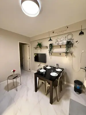 a living room with a table and a television at 1BR Condo with balcony near MOA,Parqal,Solaire in Manila