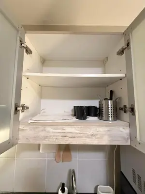 a kitchen shelf with pots and pans on it at 1BR Condo with balcony near MOA,Parqal,Solaire in Manila