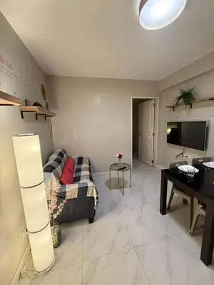 a living room with a couch and a desk at 1BR Condo with balcony near MOA,Parqal,Solaire in Manila