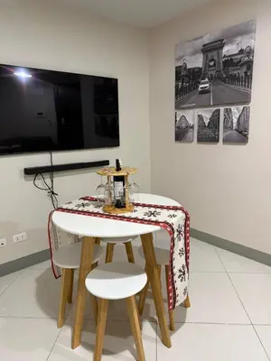 a table and two chairs in a room with a tv at Condo in BGC by MichVist - Uptown Parksuites Tower 2 in Manila