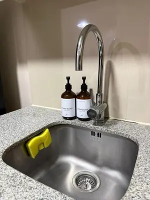 a kitchen sink with two bottles on it at Condo in BGC by MichVist - Uptown Parksuites Tower 2 in Manila