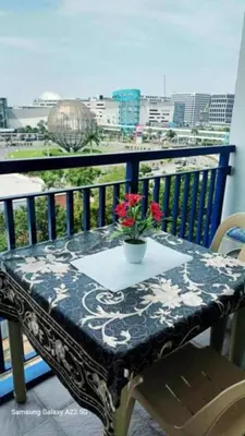 a table with flowers on top of a balcony at Juliza's MOA Staycation in Manila