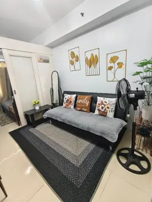 a living room with a couch and a camera at Juliza's MOA Staycation in Manila