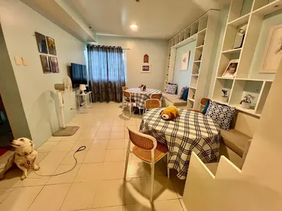 a dining room with a table and a dog in a room at Jin's Jaunt in Manila