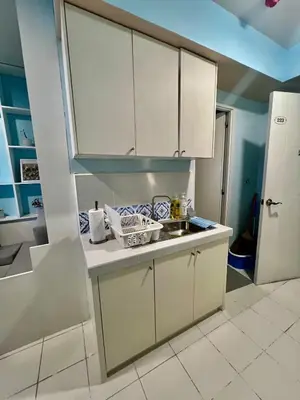 a kitchen with white cabinets and a sink at Jin's Jaunt in Manila