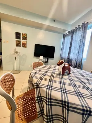 a bedroom with a bed with a horse on a table at Jin's Jaunt in Manila