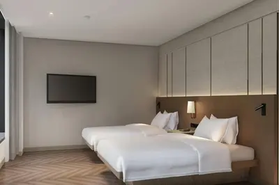 two beds in a hotel room with a flat screen tv at AC Hotel by Marriott Manila in Manila