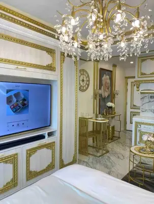 a bedroom with a television and a chandelier at Royal Studio in Manila