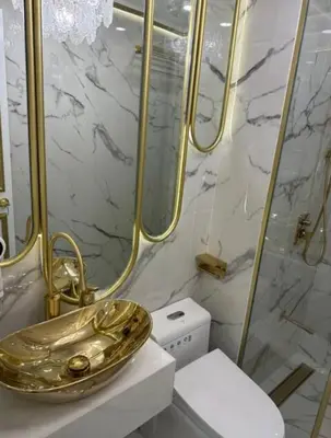 a bathroom with a gold sink and a toilet at Royal Studio in Manila