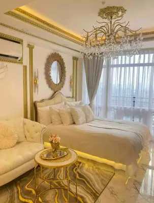 a bedroom with a bed and a couch and a chandelier at Royal Studio in Manila