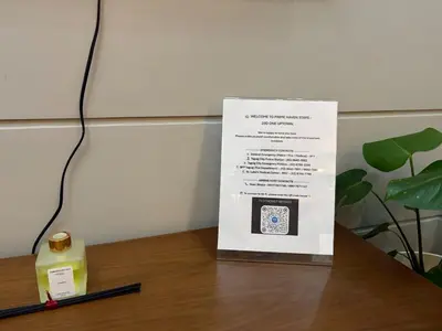 a sign sitting on top of a table next to a candle at Elegant BGC 1BR Staycation One Uptown Residence in Manila