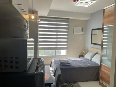 a bedroom with a bed and a window with blinds at Comfy Studio for 2 at Sunshine100 in Mandaluyong Fully equipped in Manila