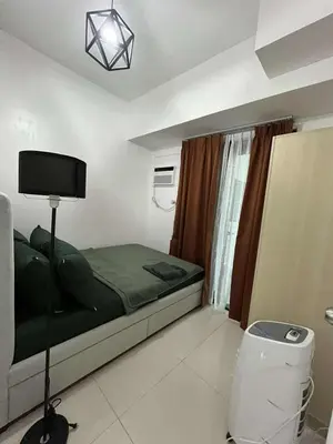 a bedroom with a bed and a tv in a room at Elements Residences 1br fully furnished with balcony in Manila