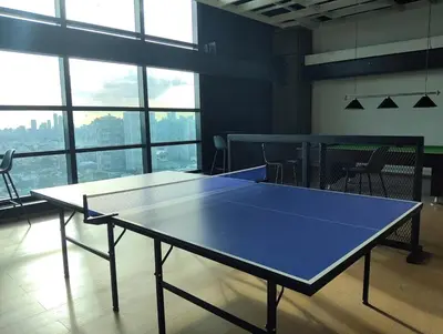 a ping pong table in a room with a large window at Elements Residences 1br fully furnished with balcony in Manila