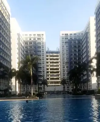 a swimming pool in front of some tall buildings at Woodox Condotel in Manila