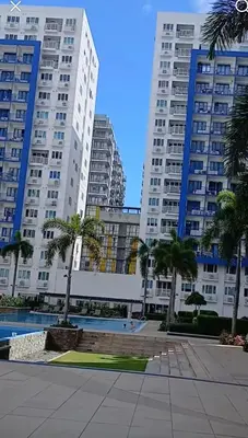 two tall buildings with palm trees in a city at Woodox Condotel in Manila