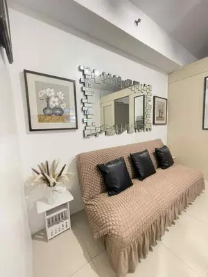 a living room with a couch and a mirror at Woodox Condotel in Manila