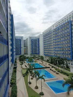 arial view of a resort with a pool and palm trees at Sea Residences Serenity in Manila