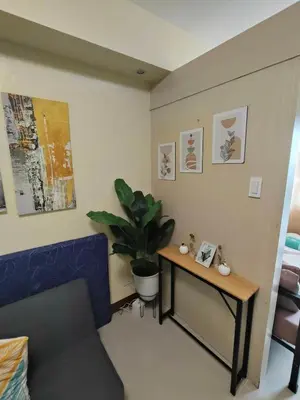 a living room with a table and a potted plant at Sea Residences Serenity in Manila