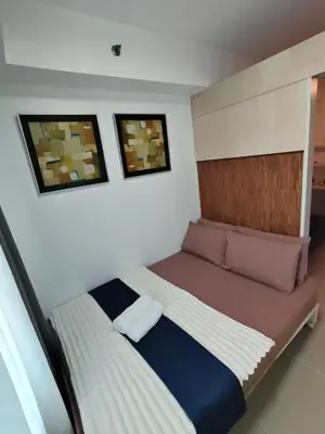a small bedroom with a bed and two pictures on the wall at Sea Residences Serenity in Manila
