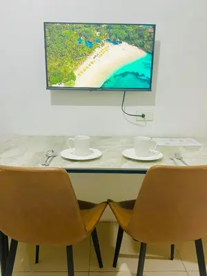 a table with two chairs and a tv on a wall at Rooms near Aiport - Credit Card accepted 0995 - 448 - 8872 in Manila