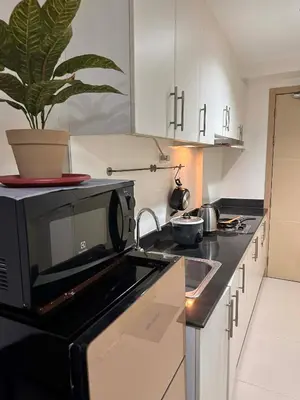 a kitchen with a black microwave and a sink at Rooms near Aiport - Credit Card accepted 0995 - 448 - 8872 in Manila