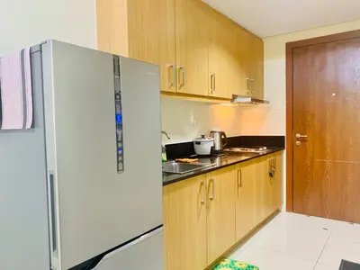 a kitchen with a white refrigerator and wooden cabinets at Rooms near Aiport - Credit Card accepted 0995 - 448 - 8872 in Manila