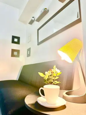a table with a lamp and a coffee cup on it at Rooms near Aiport - Credit Card accepted 0995 - 448 - 8872 in Manila