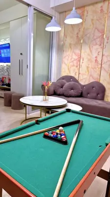 a pool table with two cuesticks on top of it at Azure Urban Resort Residences, 1BR Bahamas 15th floor in Manila