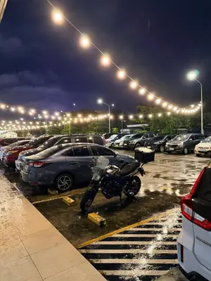 a motorcycle parked in a parking lot at night at Pool View Condo near NAIA, SMX Netflix, WiFi, PS4 in Manila