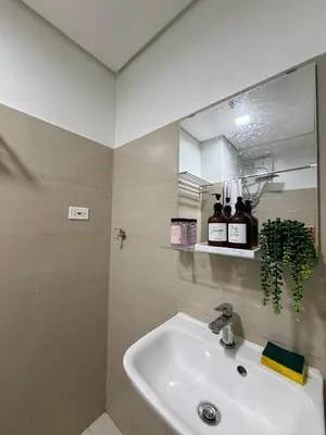 a bathroom with a sink and a mirror at Pool View Condo near NAIA, SMX Netflix, WiFi, PS4 in Manila