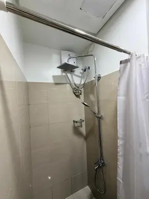 a shower in a bathroom with a shower curtain at Pool View Condo near NAIA, SMX Netflix, WiFi, PS4 in Manila